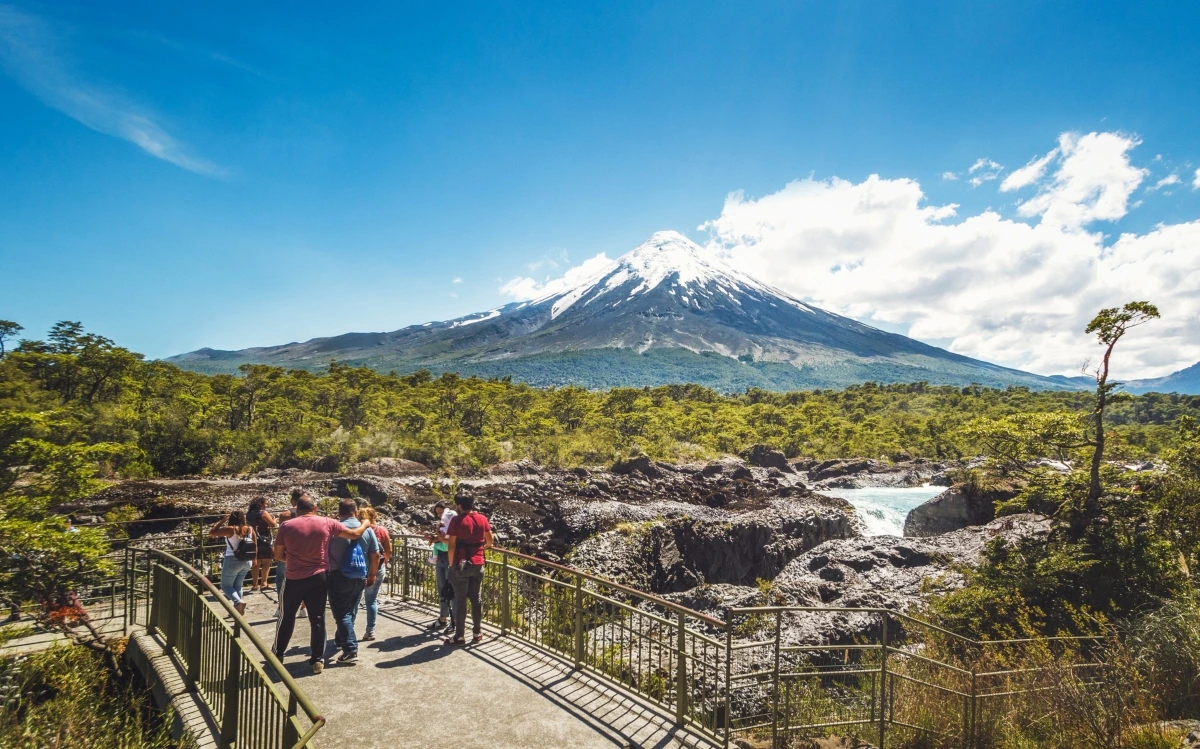 Saltos del Petrohué cascadas sobre roca volcánica negra con volcán Osorno nevado al fondo Patagonia Chile